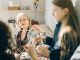 A cozy family moment with grandmother teaching granddaughter crochet indoors.